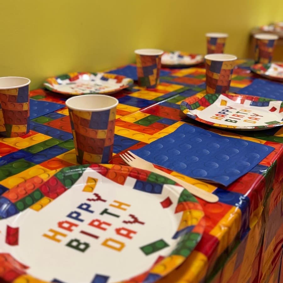 A party table set with primary-coloured building brick plates and cups