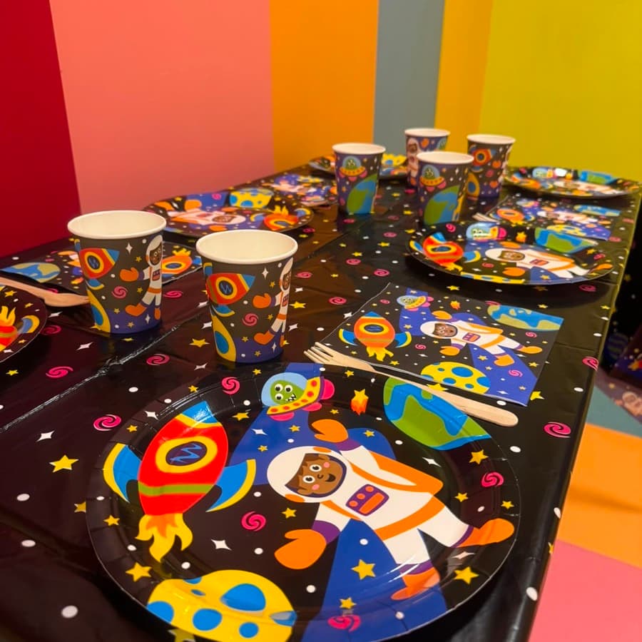 A party table set with space rocket and astronaut plates, cups and napkins