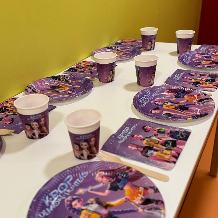 A party table set with K-Pop themed plates, cups and napkins